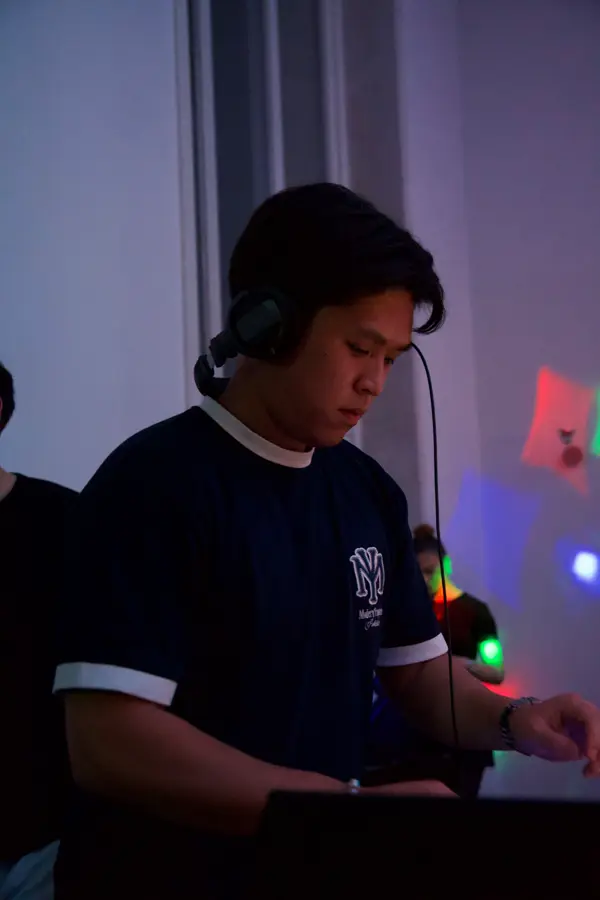DJ Dang mit Kopfhörer am Pult in lila Licht